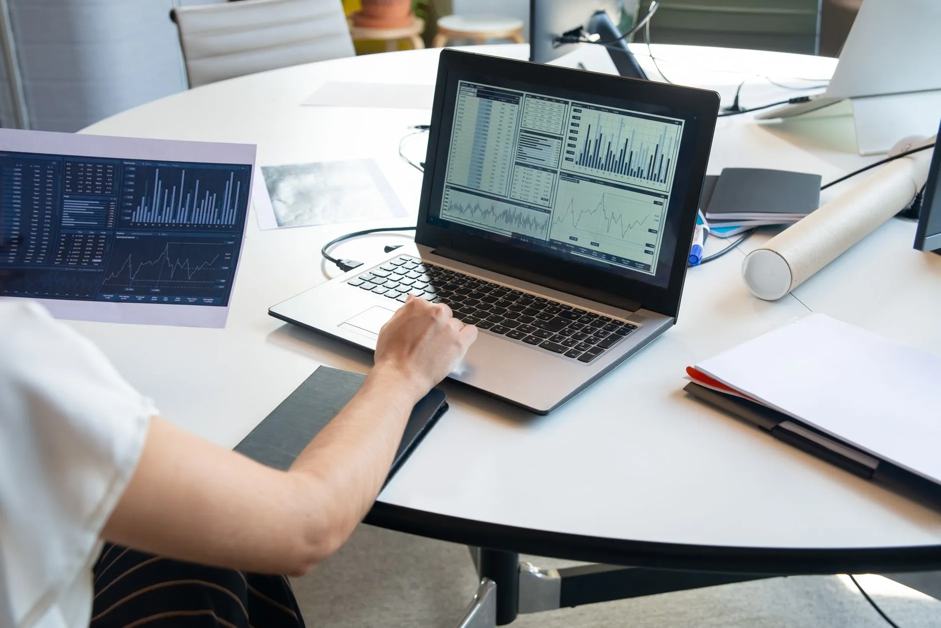 A laptop on a desk showing a dashboard of charts